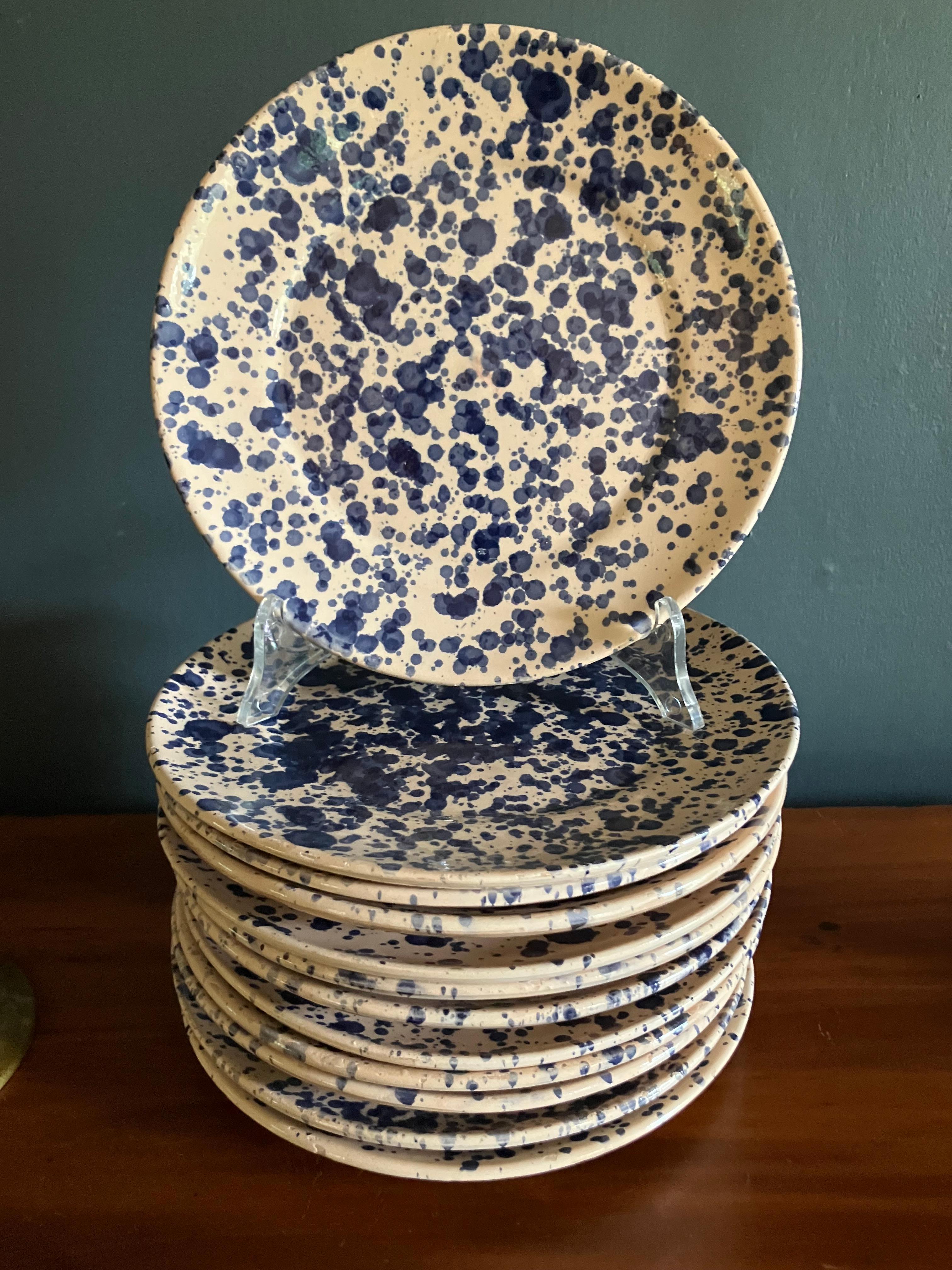 Set of Twelve Italian blue spatter plates. Twelve vintage glazed terracotta 8” luncheon or appetizer salad dessert plates with wonderfully hand spattered blue dots, each unique. Italy, Mid-20th Century. 

Dimensions: 8