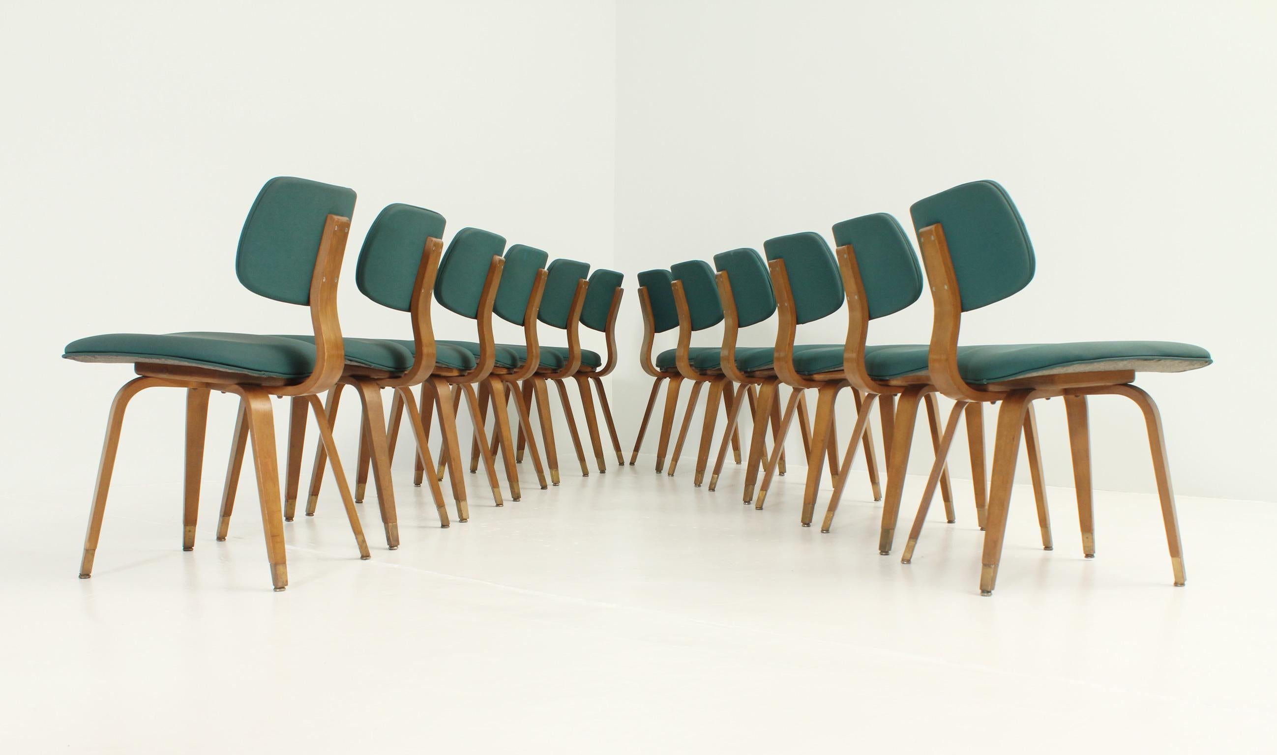 Set of twelve chairs designed in 1950's by Joe Atkinson for Thonet, USA, only produced in the States. Birch plywood, brass fittings and original green vinyl.