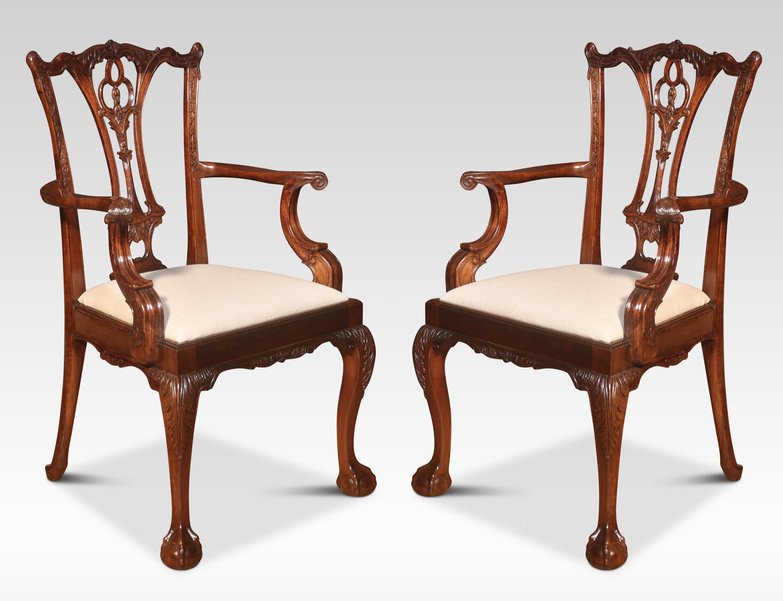 Set of twelve mahogany dining chairs, the set consisting of two carvers and ten chairs. Each with yoked crest rail above a pierced splat with quatrefoil cut-outs over a drop-in seat. All raised up on cabriole supports terminating in claw and ball