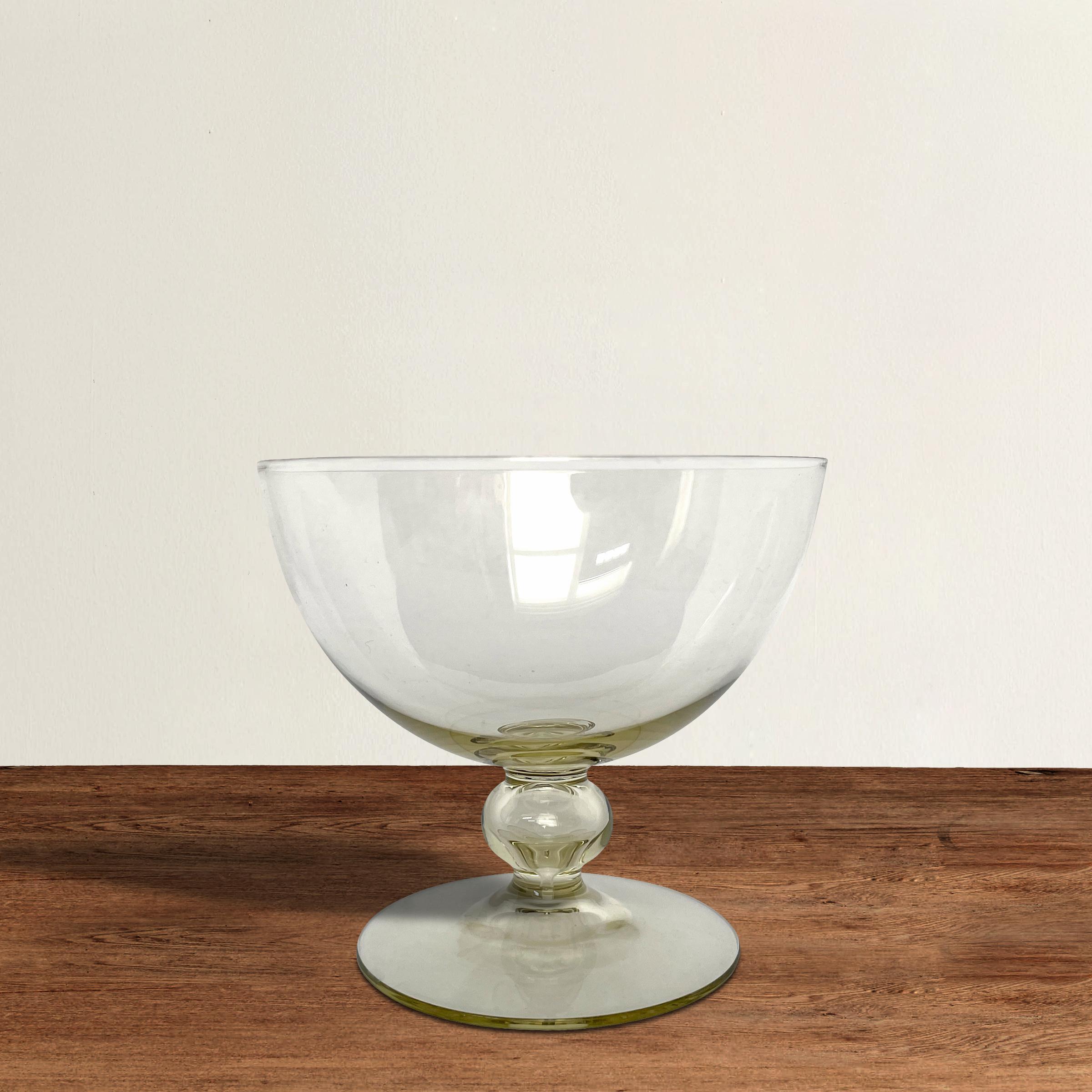 A beautiful set of twelve mid-20th century Venetian yellow glass champagne coupes, each is whisper thin with a captured bubble in its stem.