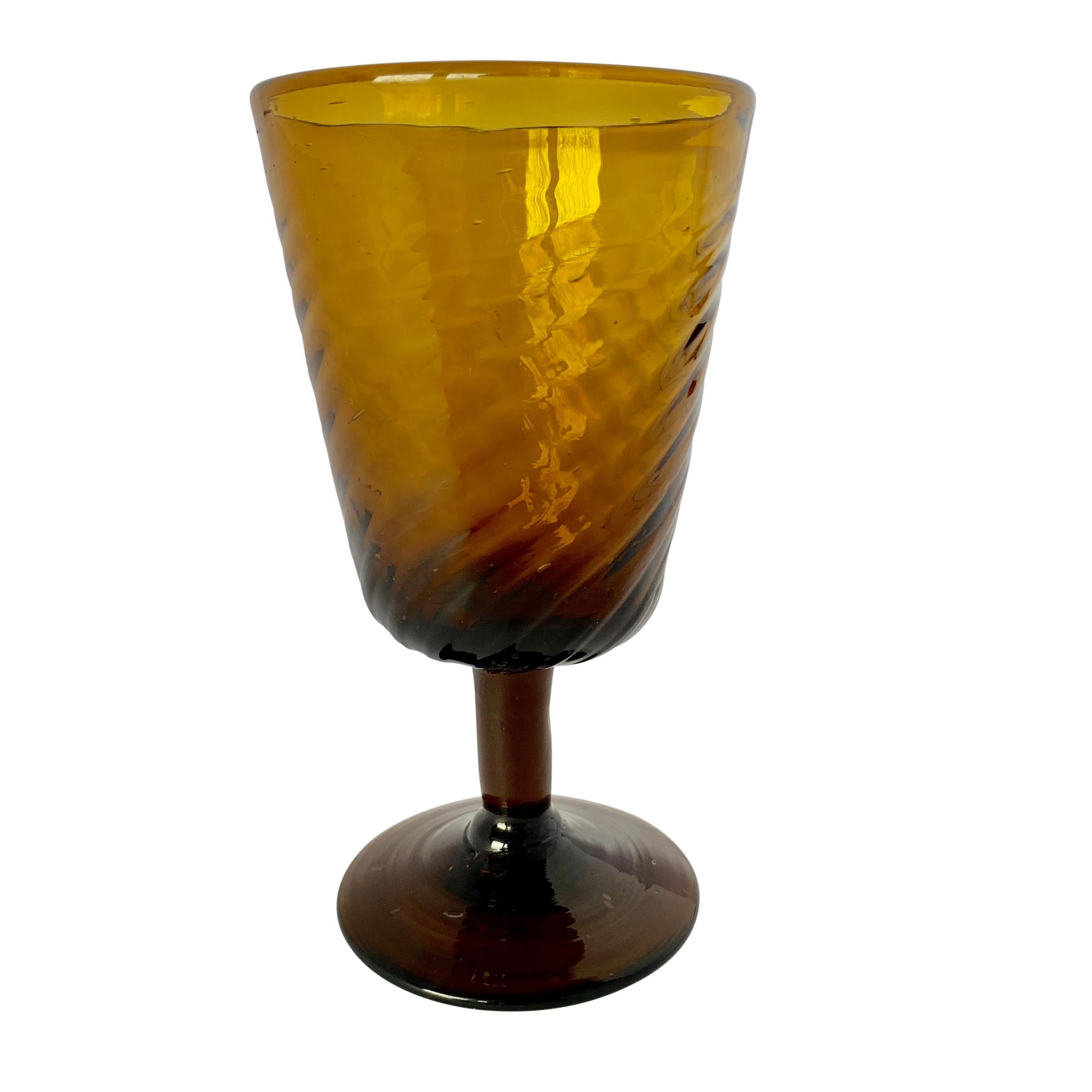 A gorgeous set of twelve mid-20th century Italian hand-blown amber colored wine glasses with a beautiful twist patterned goblet.