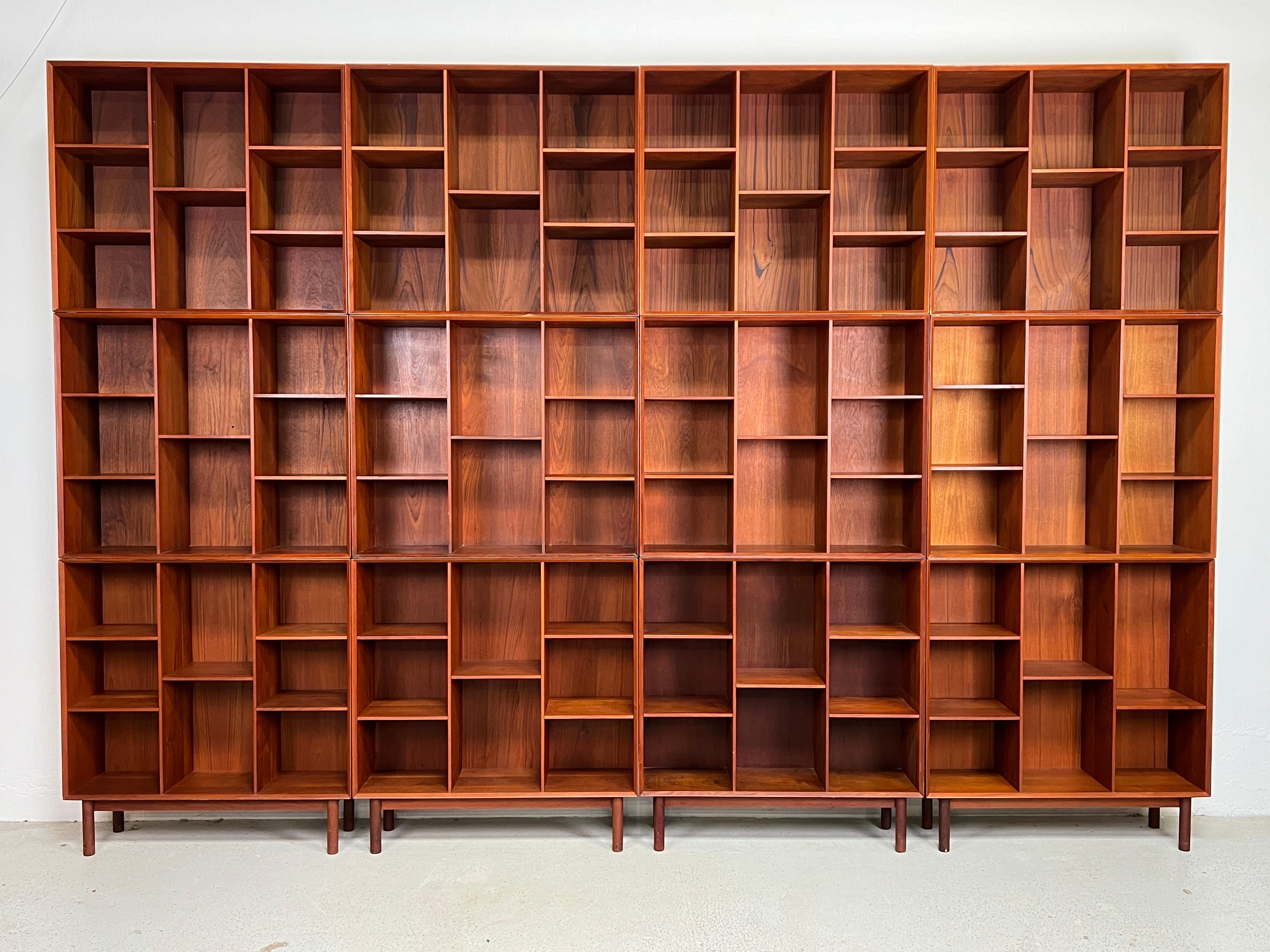 A large twelve piece modular bookcase designed by Peter Hvidt and Orla Mølgaard-Nielsen. Solid teak construction with finger joints and adjustable shelves with hidden hardware. 

Each cabinet measures 35.5w x 10d x 30h and the legs measure 7