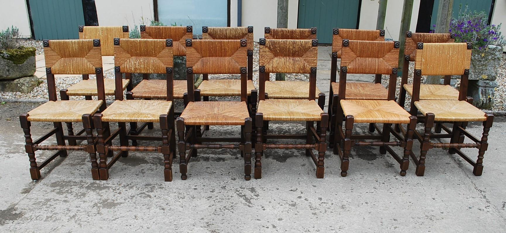 A good set of 12 harlequin rush-seated chairs, in solid oak with turned legs and stretchers. Nice detailing with the use of turned bosses to the corners. The set is made up of two sets of six that are almost identical. The condition is generally