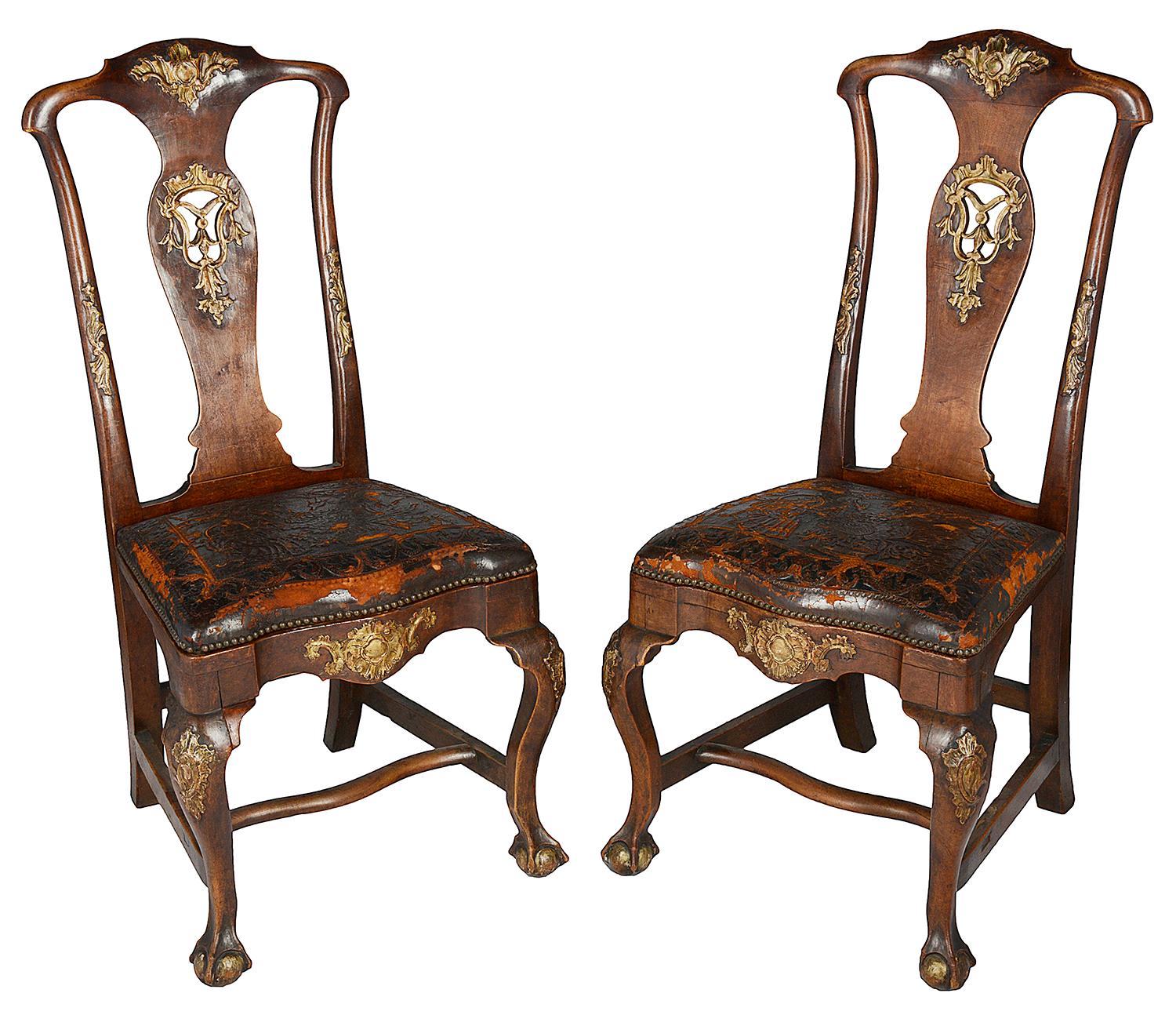 A very good quality set of twelve 18th century Portuguese dining chairs, each with carved and fretted gilded foliate decoration, stuff over embossed leather seats, raised on elegant cabriole legs, united by H stretchers.