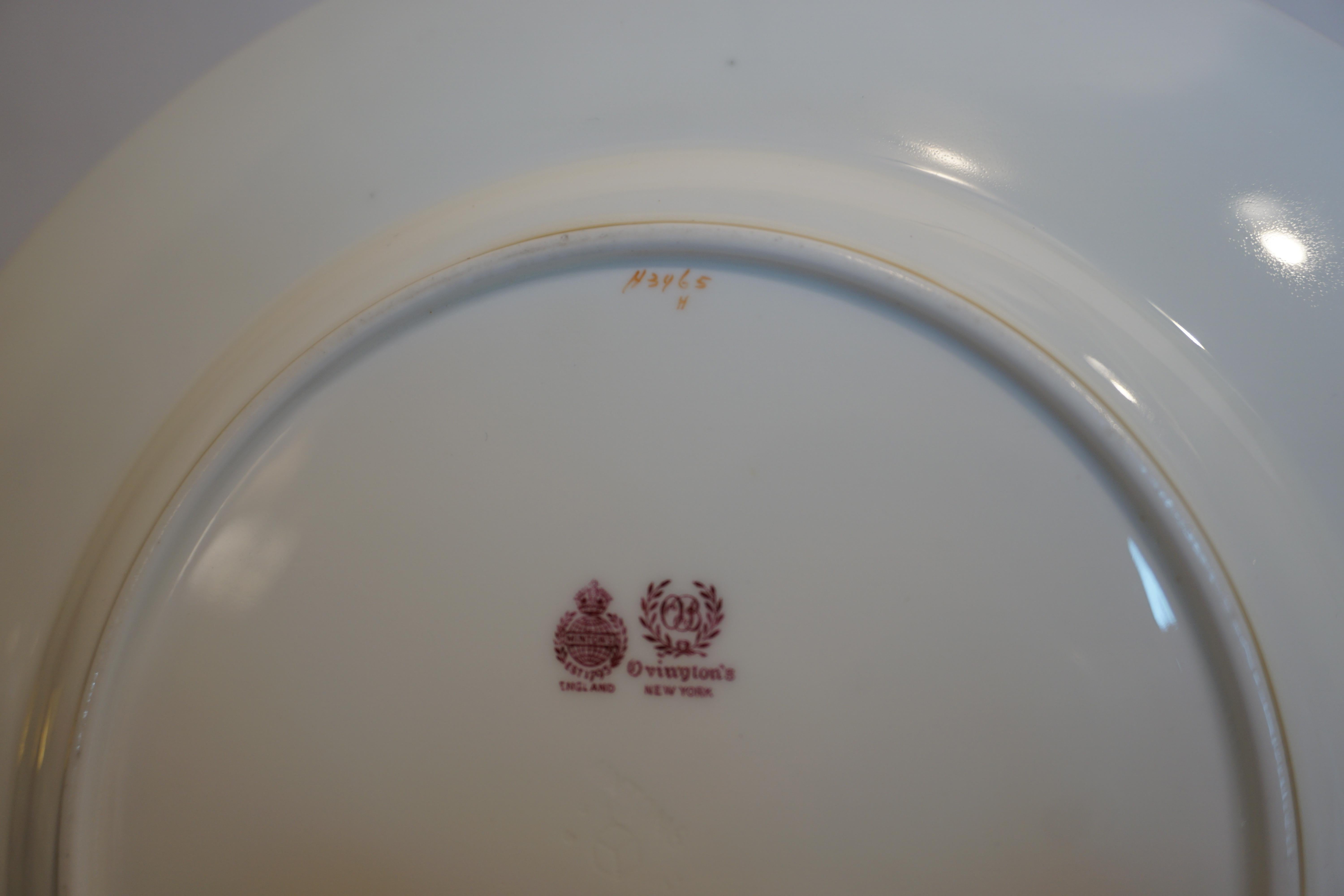 Se trata de un impresionante juego de doce platos llanos Royal Doulton con borde estriado y decoración arabesca dorada en relieve. Se fabricaron en 1905 exclusivamente para Gilman Collamore en Nueva York. Miden 10,5 pulgadas de diámetro. Serían un