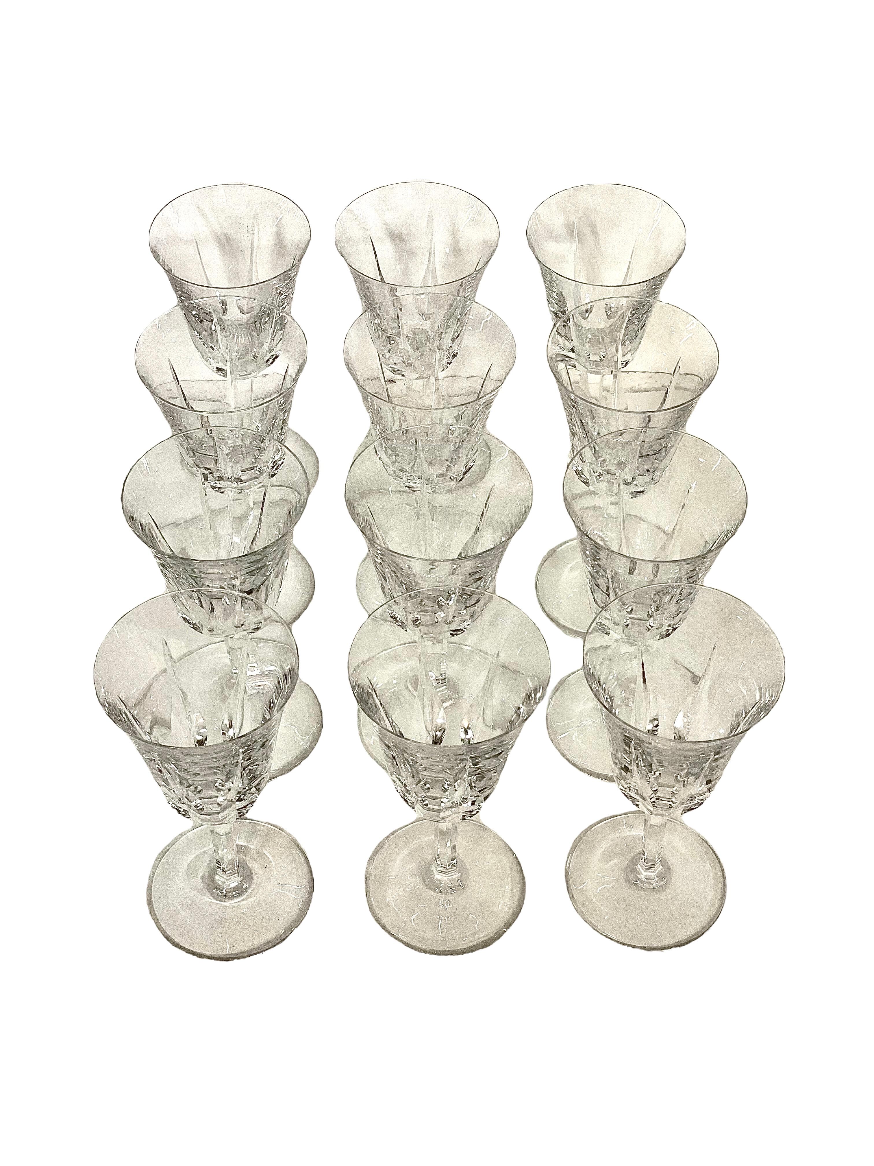 An exceptional set of 12 crystal water glasses in sparkling Saint-Louis crystal. The tulip-shaped chalice of each is cut with tall and pointed lozenges, while the stem features elegantly cut flat ribs. The glasses are all stamped 'Saint-Louis' under