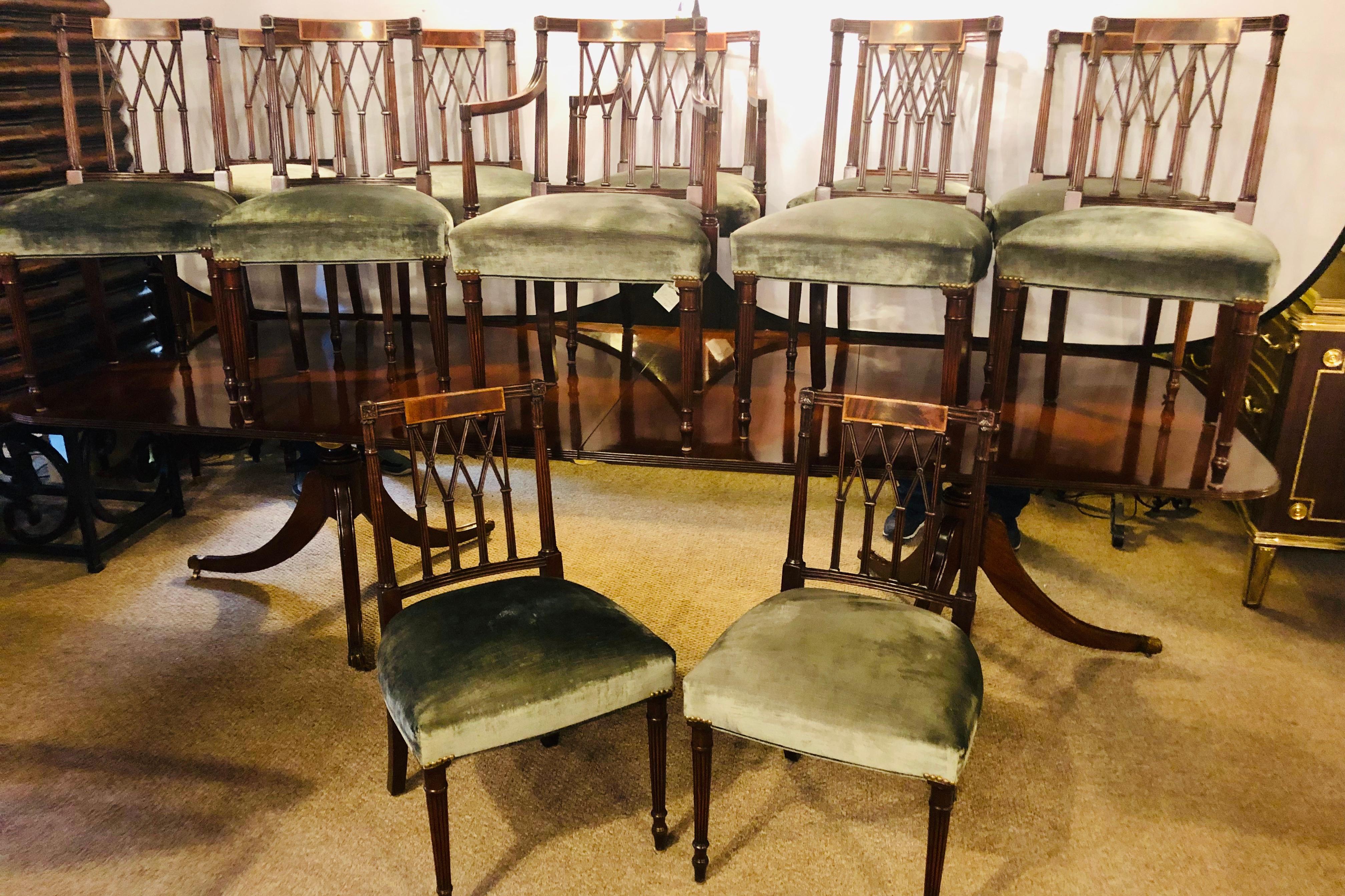 Set of twelve Sheridan style dining chairs with new upholstery. Two arm and ten side chairs make up this fine custom quality dining set of twelve chairs in the Sheridan fashion. Each reeded and tapering leg terminated in a capital column-form top