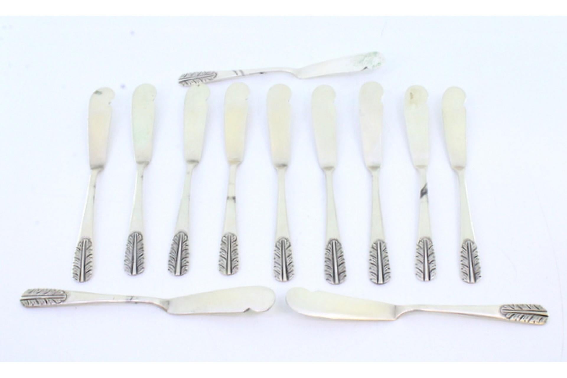 Description: Set of twelve silver butter knives with embossed handles. Metal: Silver. Origin: Portuguese. Brand: Cabeça de escravo. Weight: 259.77 grams (Set of twelve knives). Dimensions: 1.6cmx14cm. Content: 833/1000. Assay Mark: Yes, between 1938