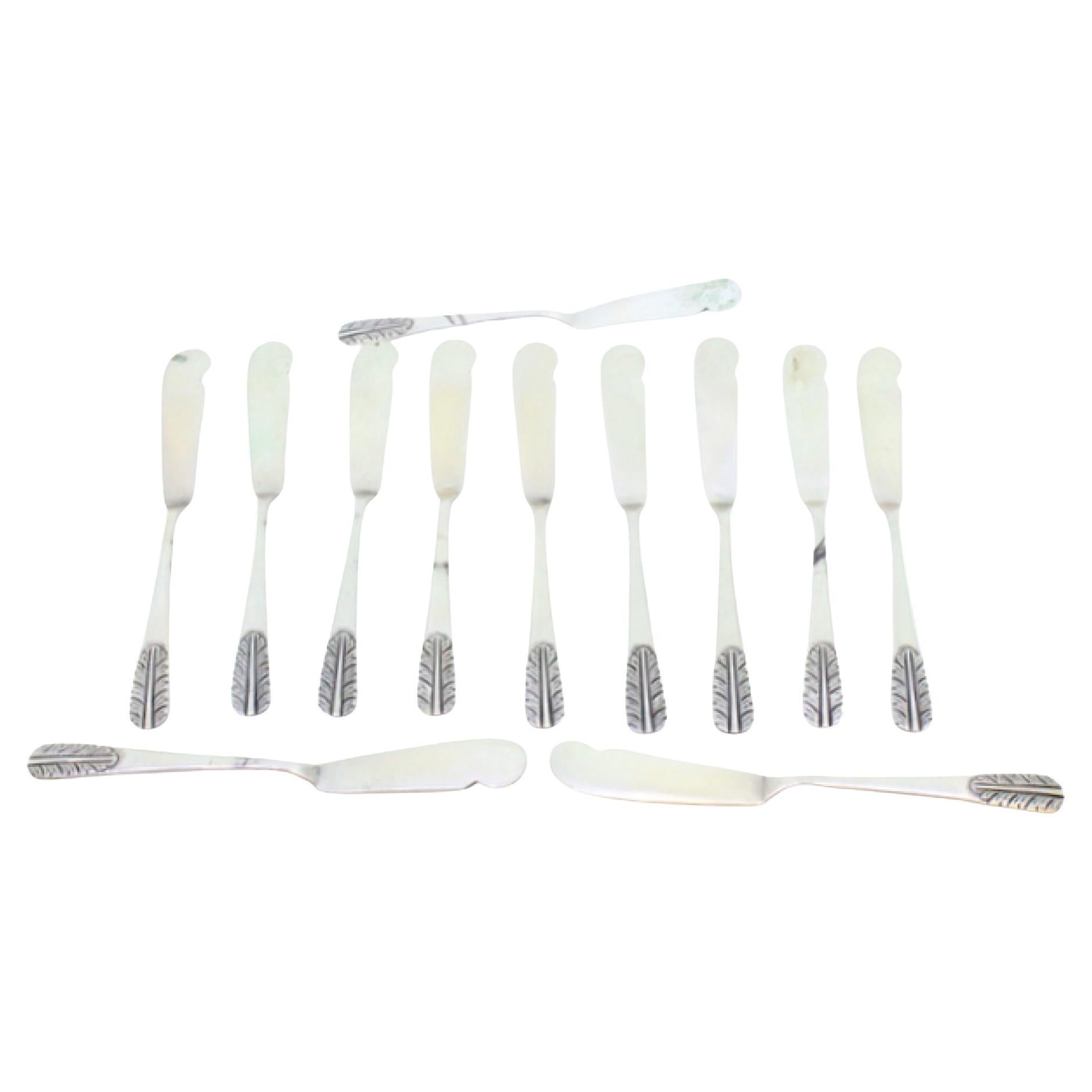 Set of twelve silver butter knives with embossed handles