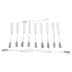 Set of twelve silver butter knives with embossed handles