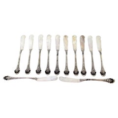 Set of twelve silver butter knives with reliefs along the handle