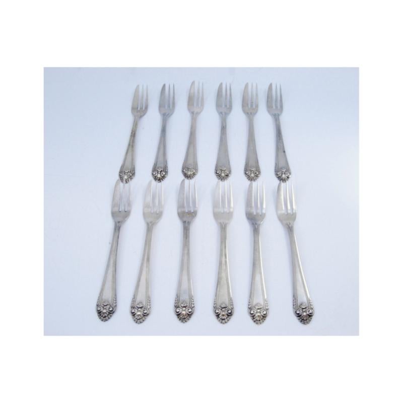 Description: Set of twelve silver cake forks with grooves and shells on the handles. Metal: Silver. Origin: Portuguese. Brand: Cabeça de escravo. Weight: 377.81 grams (Set of twelve forks). Dimensions: 14x2cm. Content: 833/1000. Assay Mark: Yes,