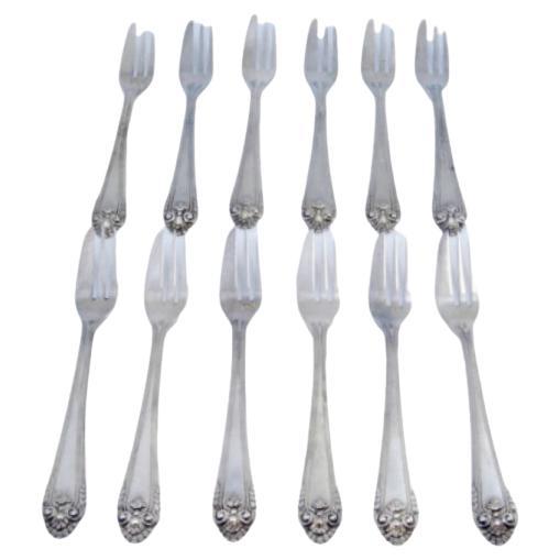 Set of twelve silver cake forks with friezes and shells on the handles