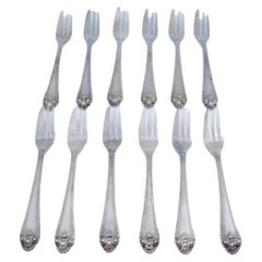 Set of twelve silver cake forks with friezes and shells on the handles