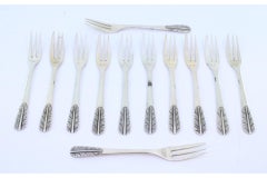 Set of twelve silver cake forks with reliefs on the handles