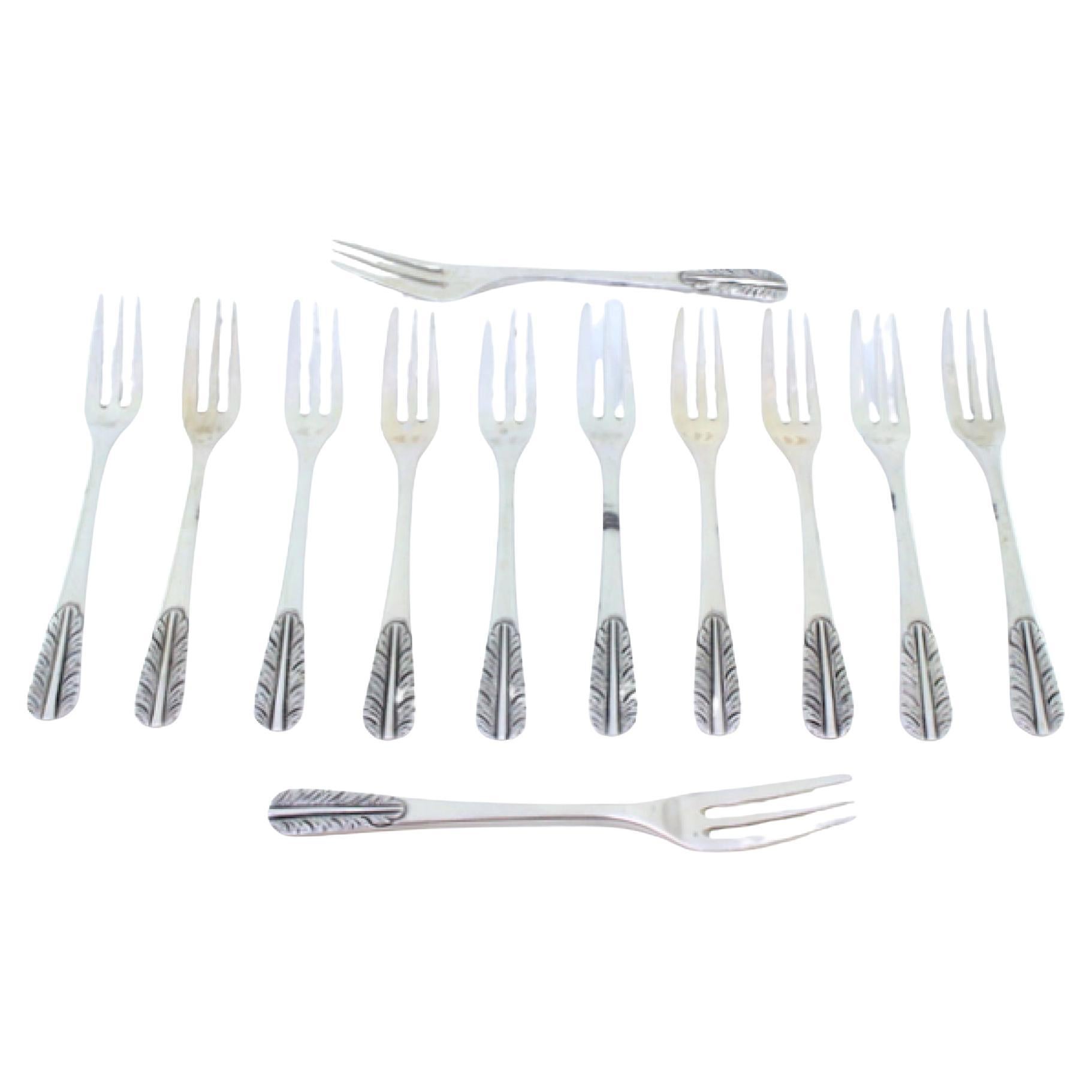 Set of twelve silver cake forks with reliefs on the handles