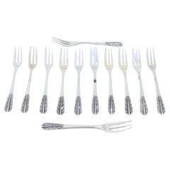 Set of twelve silver cake forks with reliefs on the handles