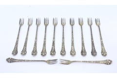Set of twelve silver cake forks with revealed and crimped handles