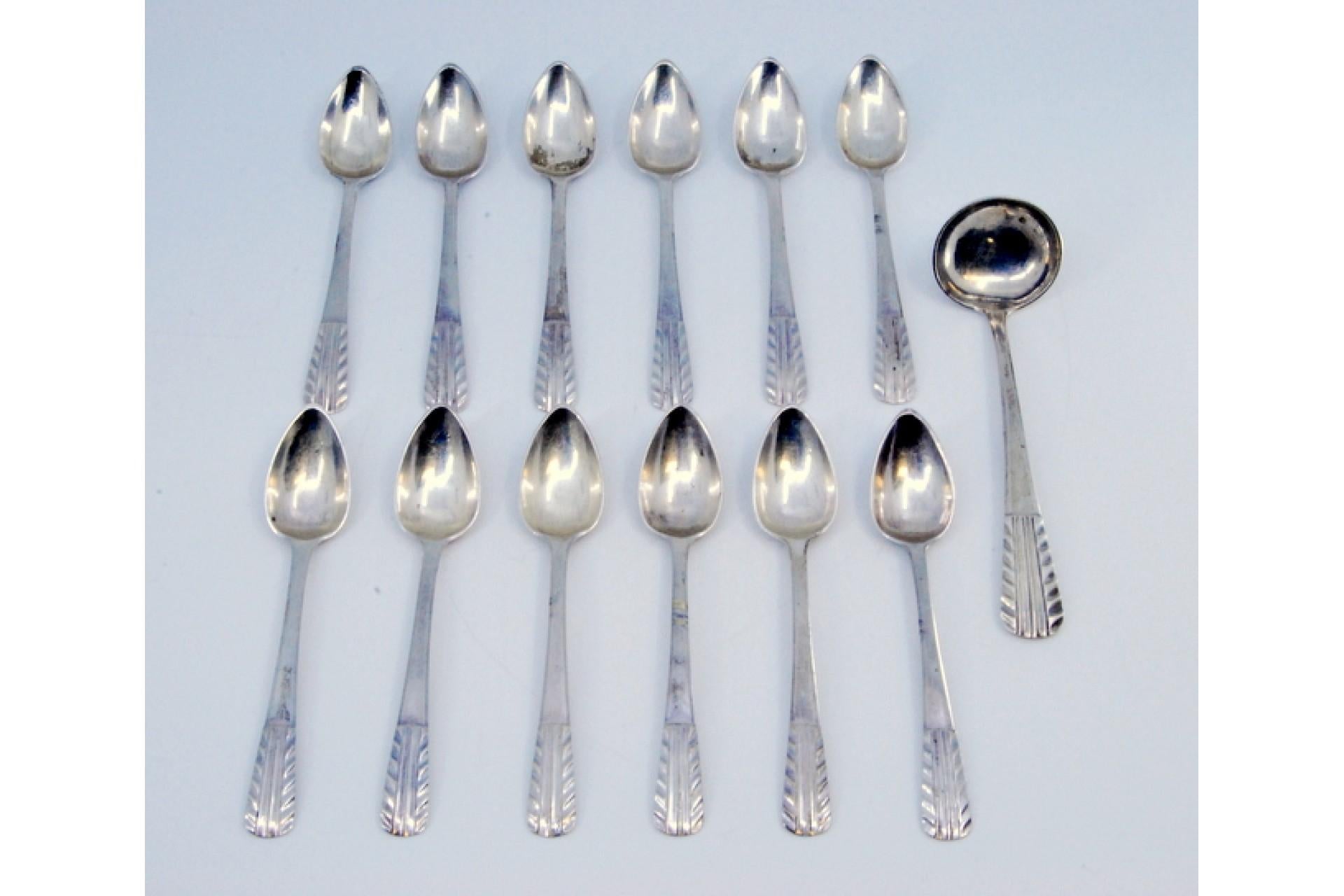 Description: Set of twelve coffee spoons and sugar ladle in silver with raised handles. . Metal: Silver. Origin: Portuguese. Brand: Porto Coroa. Weight: 201.53 grams (Set of twelve spoons and ladle). Dimensions: Shovel - 12x3.5cm Spoon - 11.5x2.2cm.