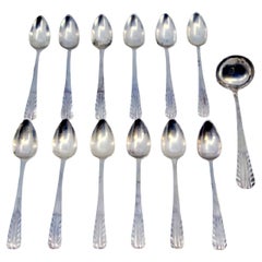 Set of twelve silver coffee spoons and sugar ladle with raised handles