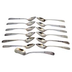 Set of twelve silver coffee spoons and sugar scoop with raised handles