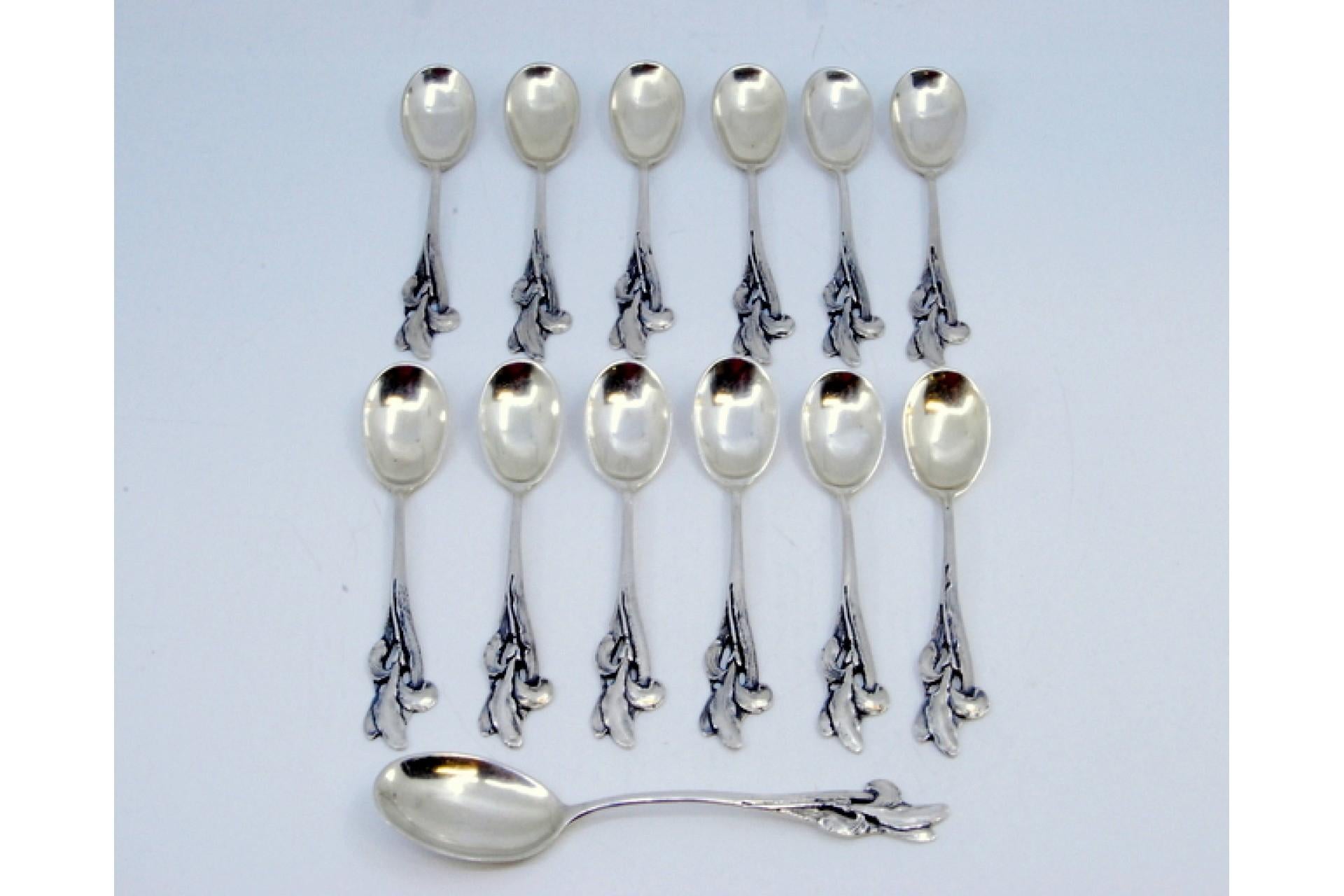 Description: Set of twelve coffee spoons and sugar shovel in silver with cut-out handles. Metal: Silver. Origin: Portuguese. Brand: javali II Title. Weight: 223.29 grams (Set of twelve spoons and shovel). Dimensions: Shovel - 13.5x2.9cm Spoon -