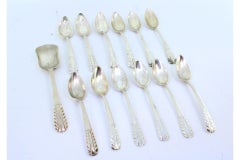 Set of twelve silver coffee spoons and sugar shovel with raised handles