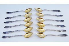 Set of twelve silver coffee spoons with embossed handles and golden shells