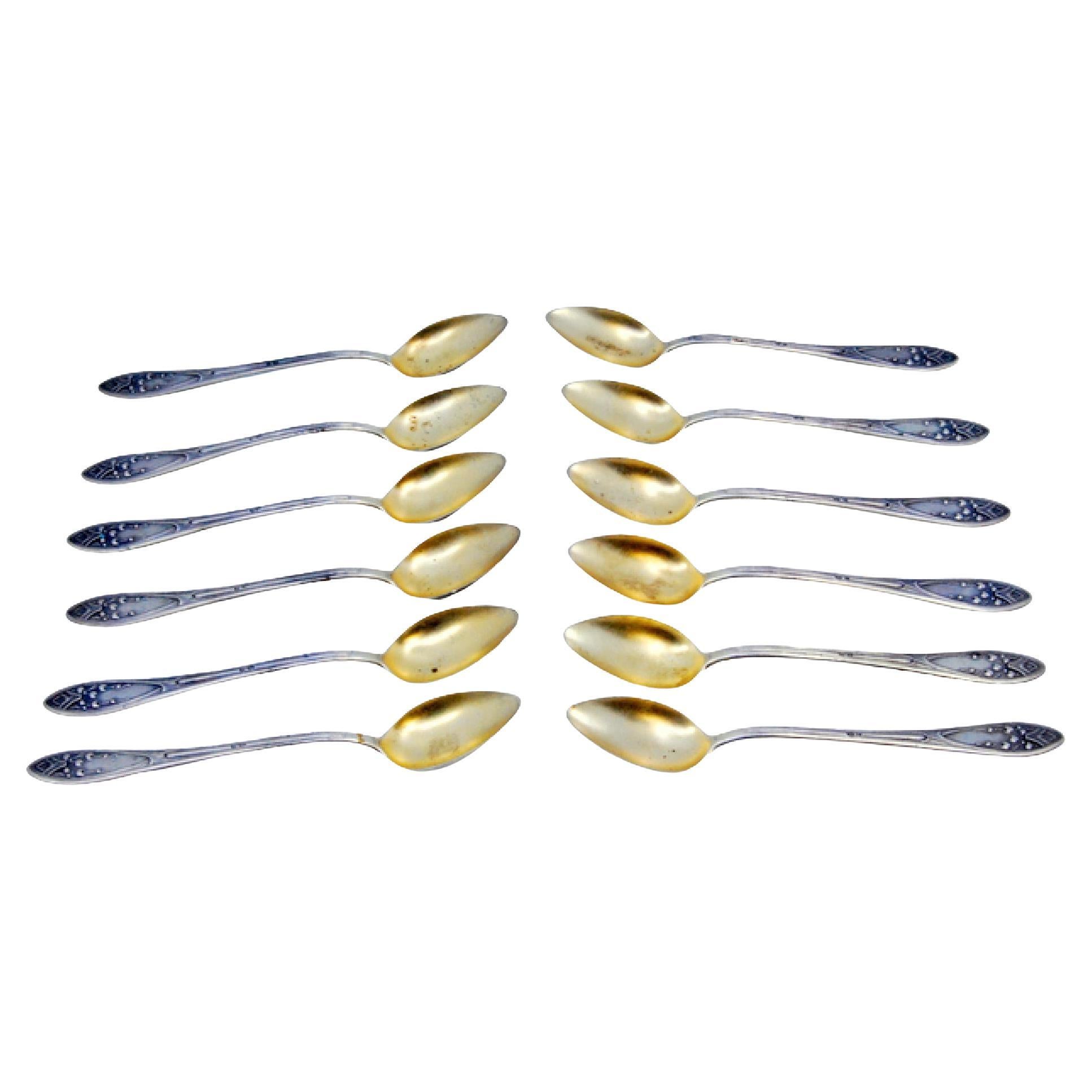 Set of twelve silver coffee spoons with embossed handles and golden shells For Sale