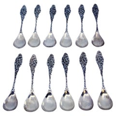 Set of twelve silver coffee spoons with handles cut into scrolls and shells