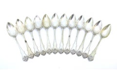 Set of twelve silver dessert spoons with raised handles