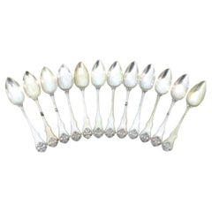 Set of twelve silver dessert spoons with raised handles