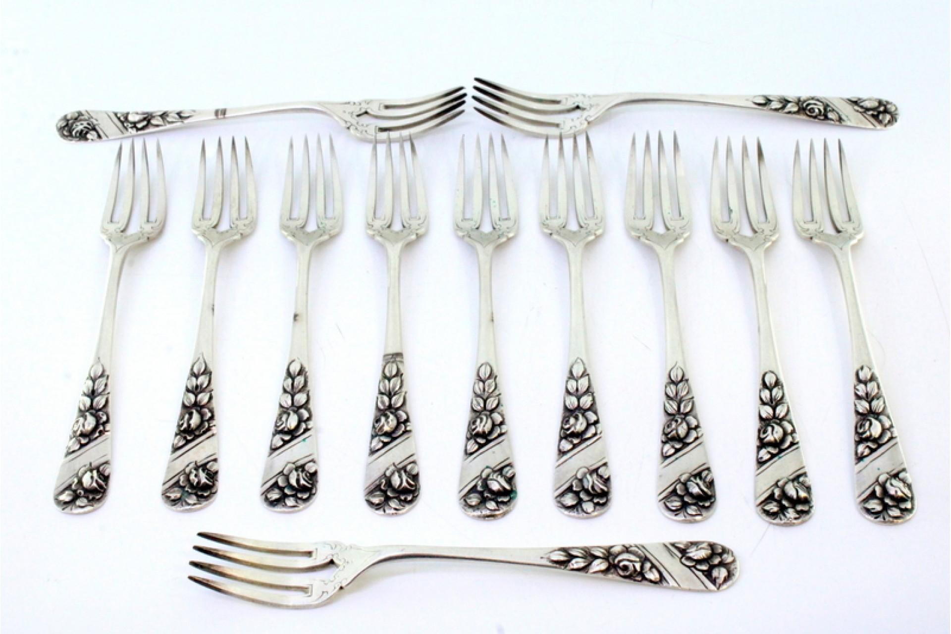 Description: Set of twelve silver forks with reliefs on the handles involving cards for monograms. Metal: Silver. Origin: Portuguese. Brand: javali II Title. Weight: 535.54 grams (Set of twelve forks). Dimensions: 2.5cmx16.5cm. Content: 833/1000.