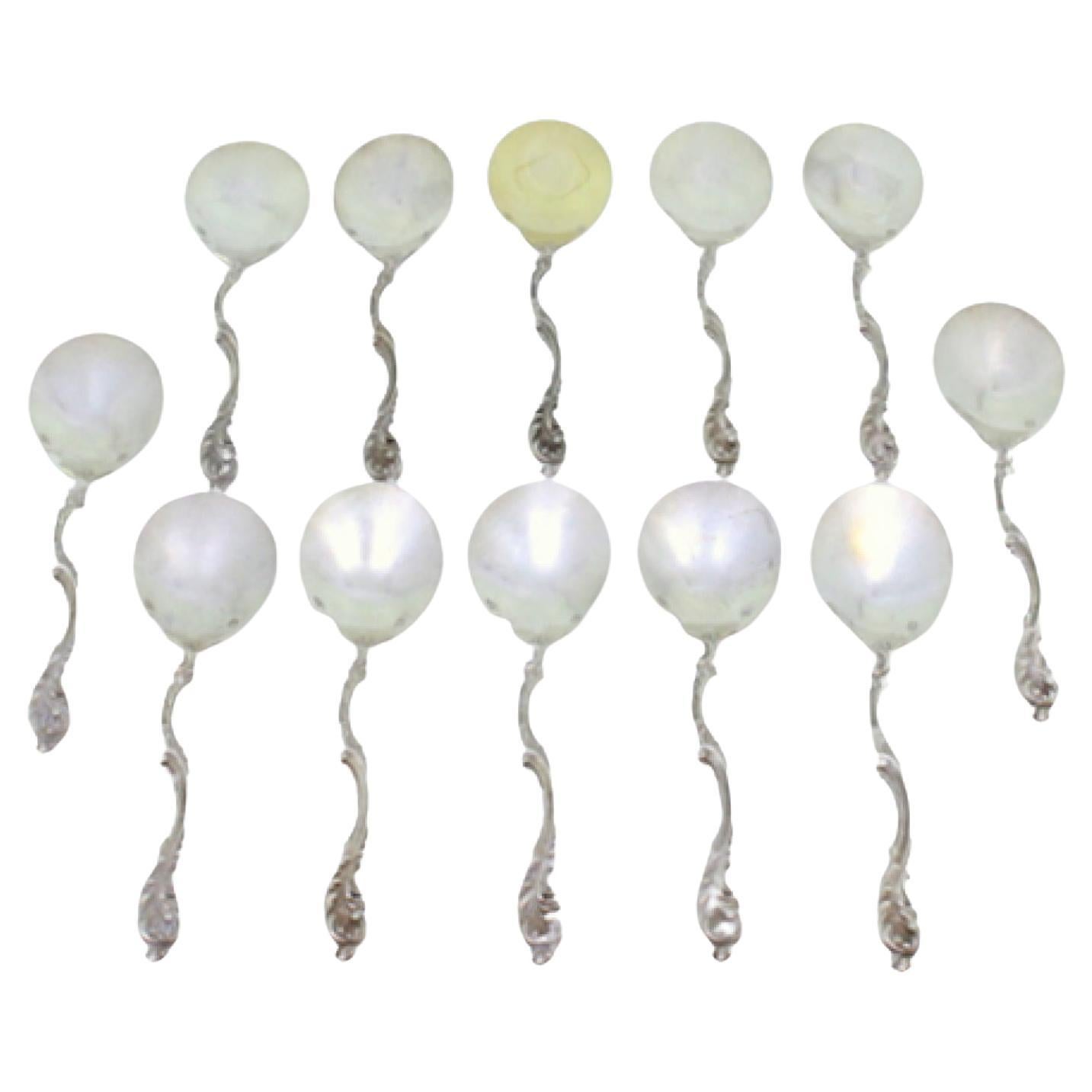 Set of twelve silver ice cream scoops with smooth shells and twisted handles