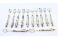 Set of twelve silver oyster forks with three tines and raised handles