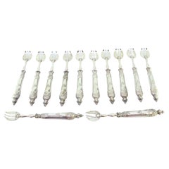 Set of twelve silver oyster forks with three tines and raised handles