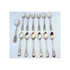 Set of twelve silver tea spoons and sugar shovel with raised handles