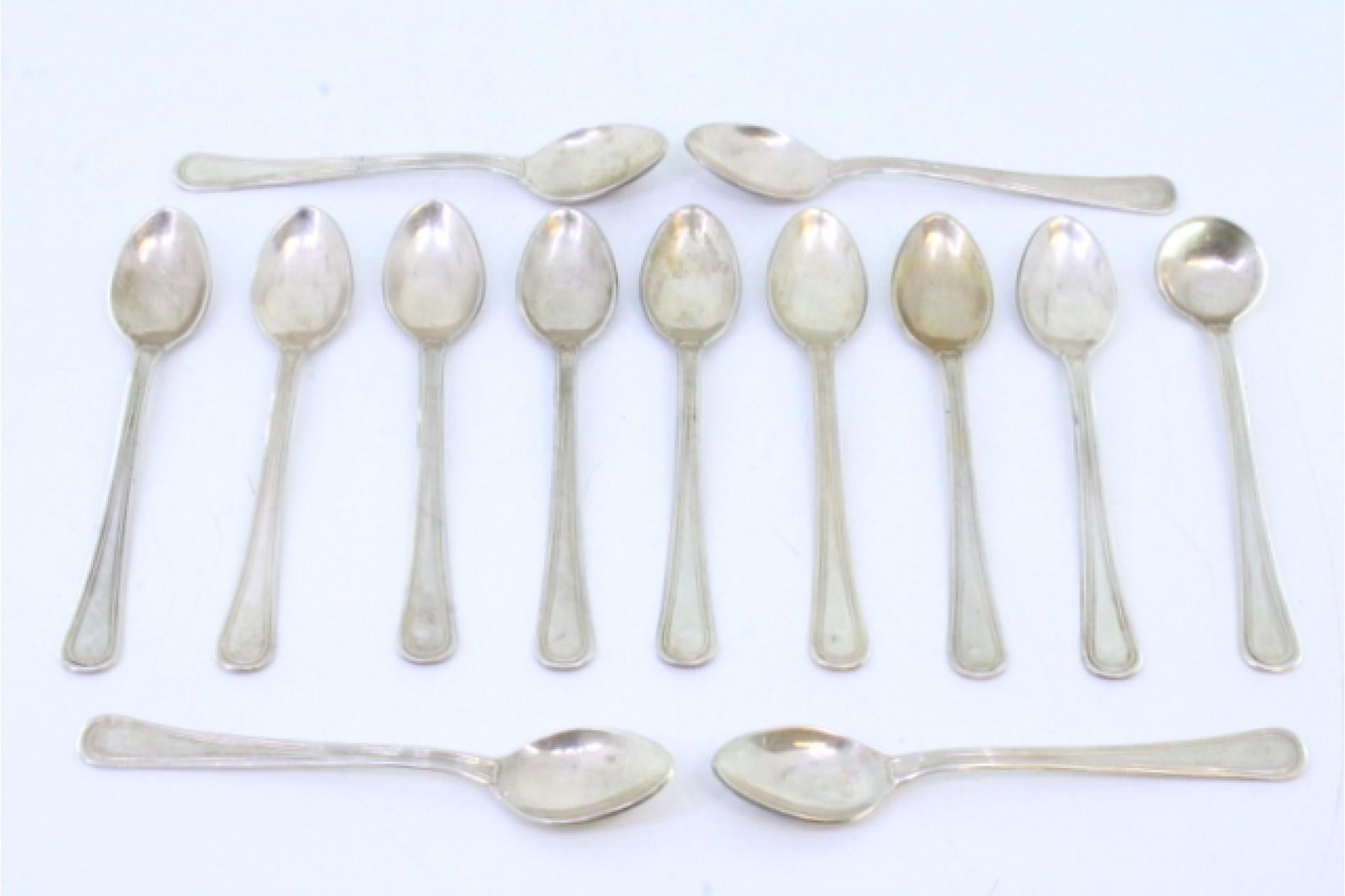 Description: Set of twelve coffee spoons and sugar ladle in silver with grooves along the handles. Metal: Silver. Origin: Spanish. Brand: Estrela. Weight: 160.85 grams (Set of twelve teaspoons and ladle). Dimensions: Ladle - 10.5x2.2cm Shovel -
