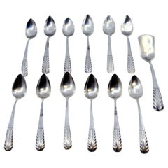 Set of twelve silver teaspoons and sugar scoops with raised handles