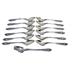 Set of twelve silver teaspoons and sugar shovel with reliefs on the handles