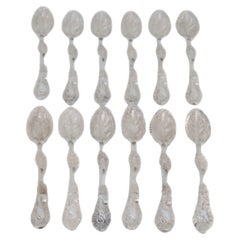 Set of twelve silver teaspoons embossed w/ tree trunks, leaves 
beaded shells