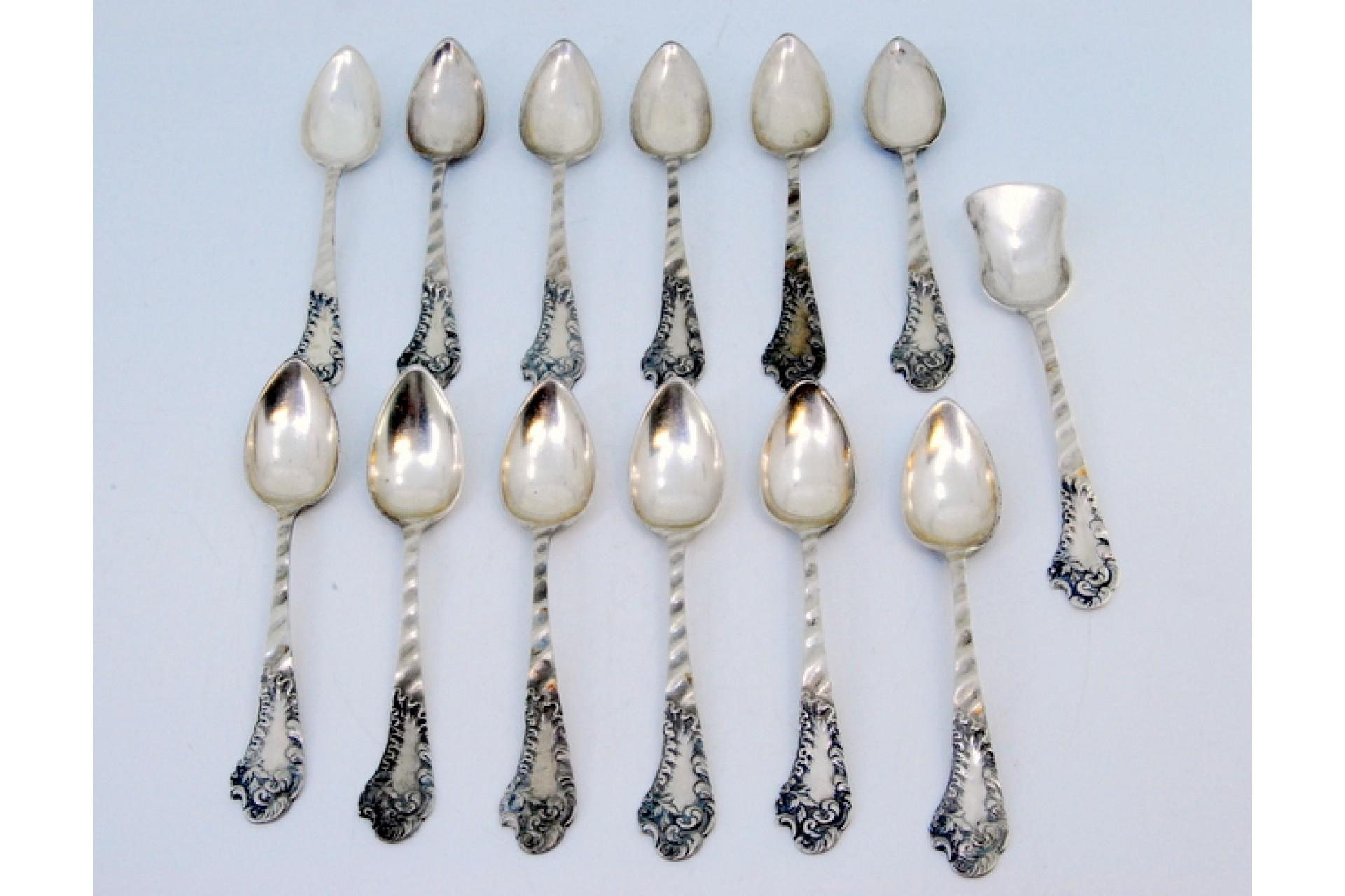 Description: Set of twelve silver spoons and sugar shovel with wavy handles and monogram cards. Metal: Silver. Origin: Portuguese. Brand: javali II Title. Weight: 279.72 grams. Dimensions: Shovel -14x3 Spoon - 13x2.6cm. Content: 833/1000. Assay