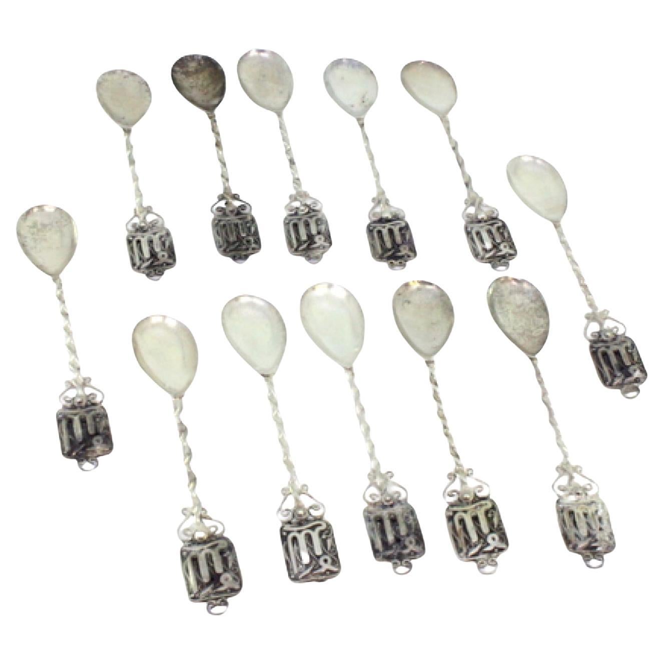 Set of twelve silver teaspoons w/ twisted handles
placed on appliquéd plates