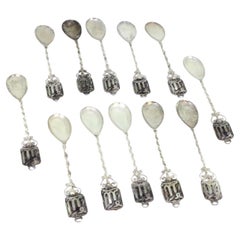 Set of twelve silver teaspoons w/ twisted handles
placed on appliquéd plates