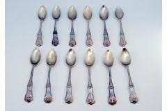 Set of twelve silver teaspoons with shells and raised grooves on the handles