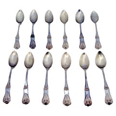 Set of twelve silver teaspoons with shells and raised grooves on the handles