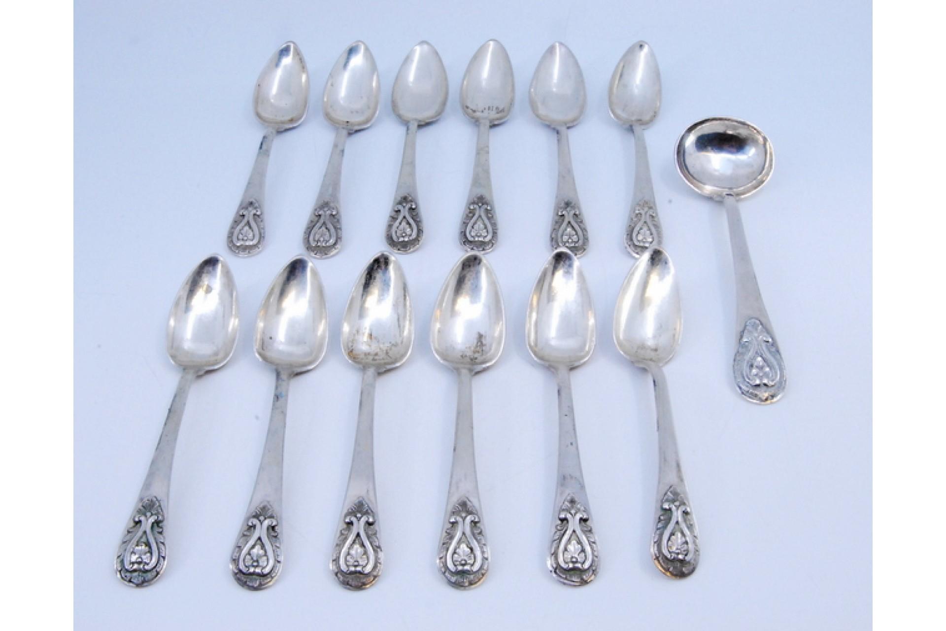 Description: Set of twelve silver teaspoons with sugar ladle and reliefs on the handles. Metal: Silver. Origin: Portuguese. Brand: Porto Coroa. Weight: 259.55 grams (Set of twelve spoons and ladle). Dimensions: Ladle - 13.5x3.8cm Spoon - 12.5x2.4cm.
