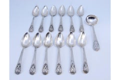 Set of twelve silver teaspoons with sugar scoop and reliefs on the handles