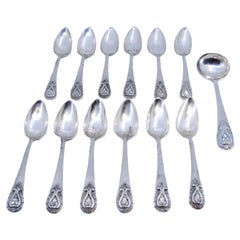 Set of twelve silver teaspoons with sugar scoop and reliefs on the handles