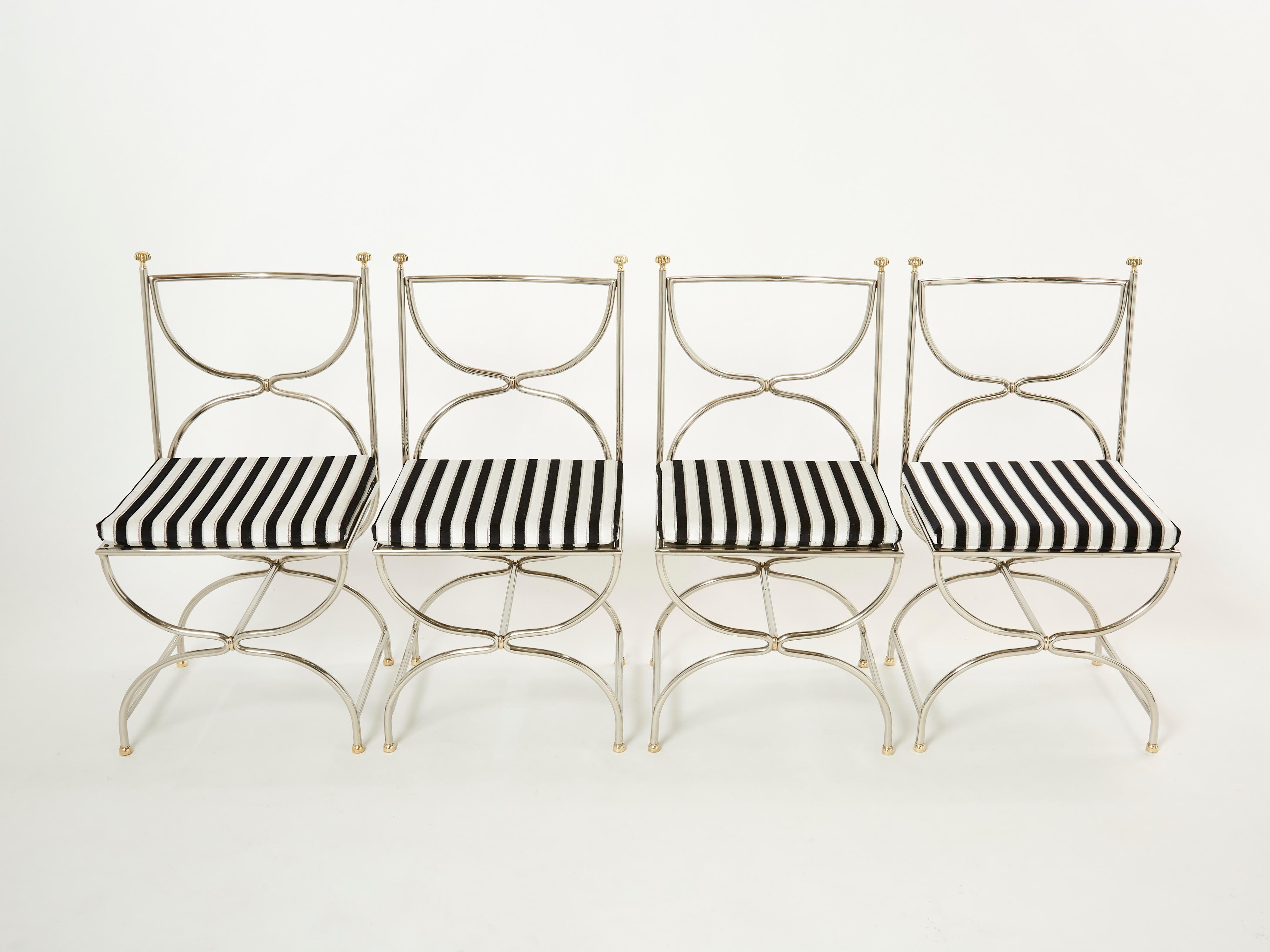Magnifique ensemble de chaises Curule Savonarola des années 1960 en acier inoxydable lourd avec des accents en laiton. Cet incroyable ensemble de douze chaises a été créé par le cabinet d'architecture d'intérieur français Maison Jansen. La structure